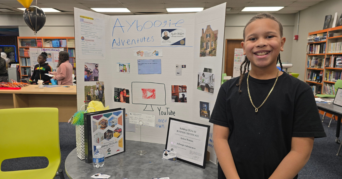 student standing next to trifold poster board